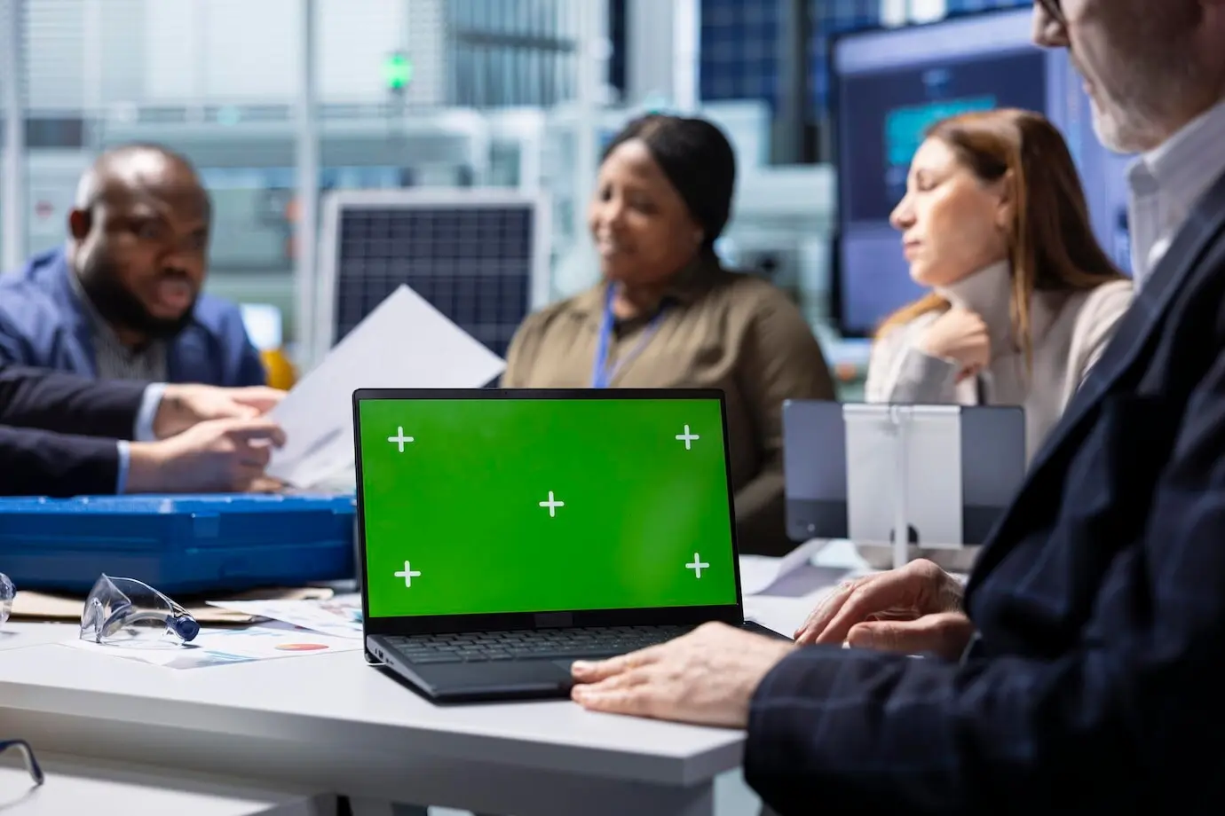 Инвесторы фабрики просматривают документацию на макете ноутбука.